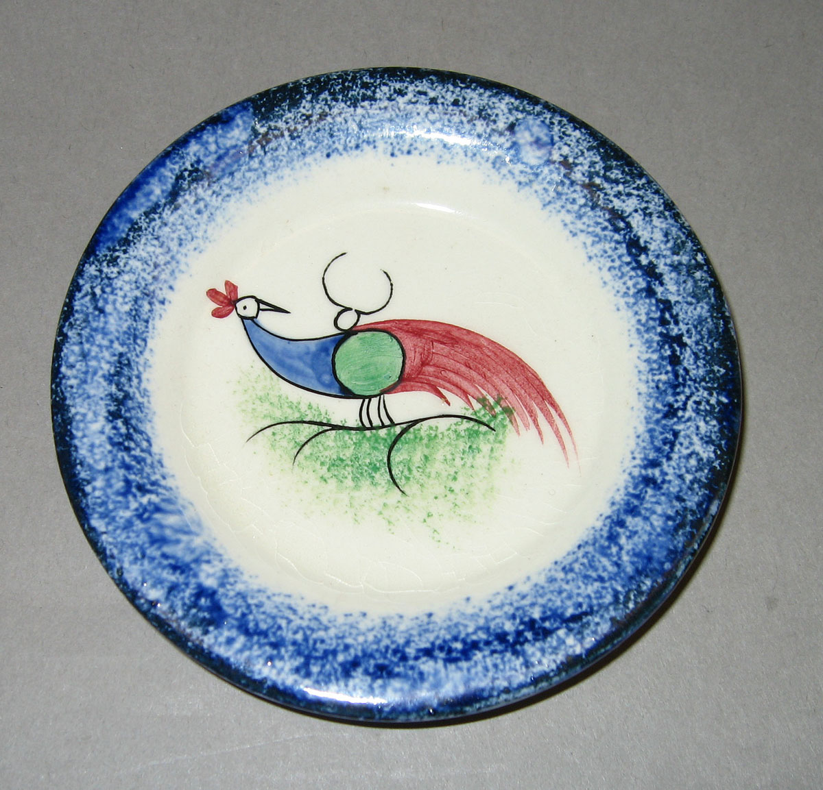 1954.0003.008 Peafowl cup plate with blue spatter rim