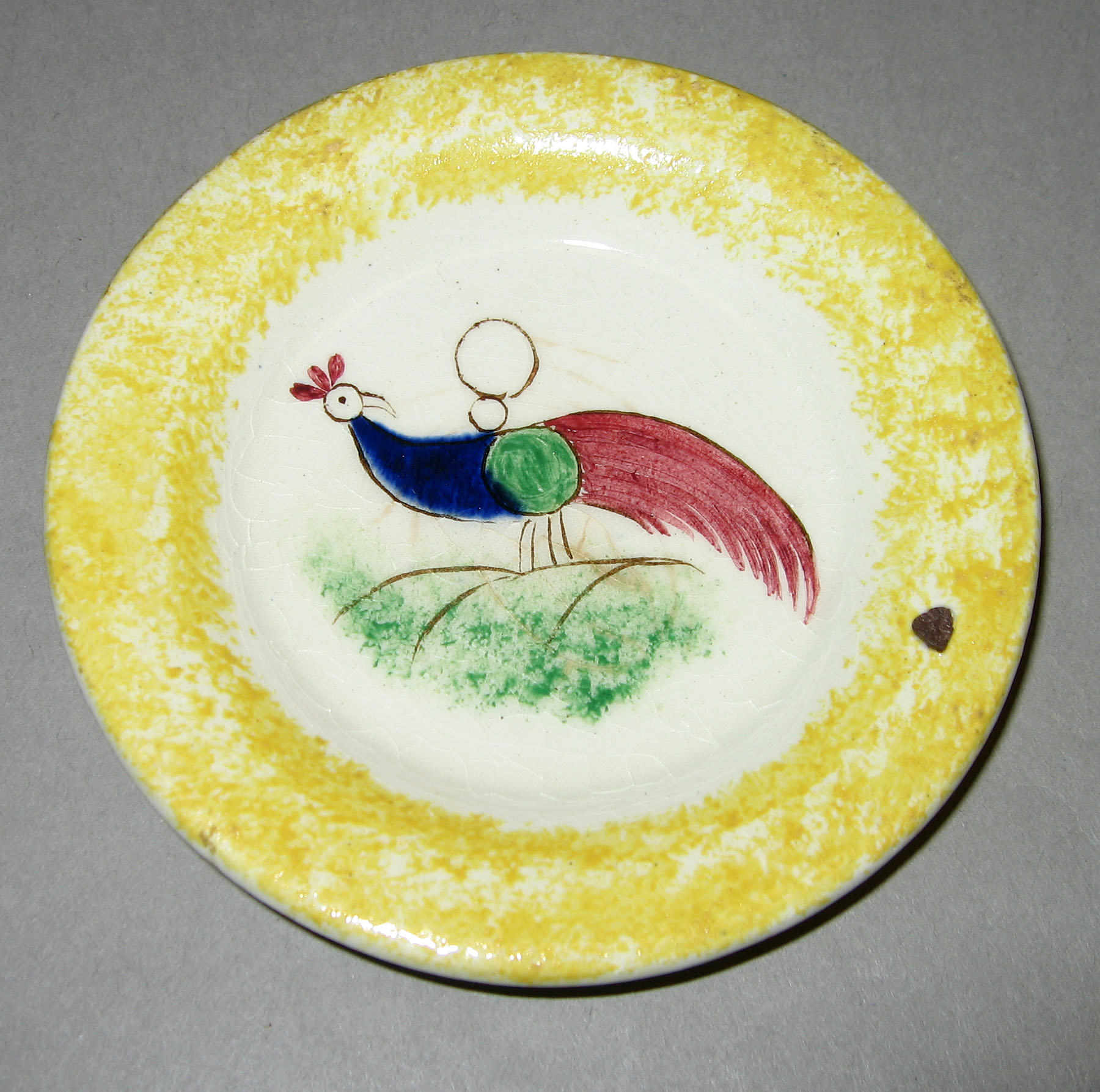 1961.0039 Peafowl cup plate with yellow spatter rim