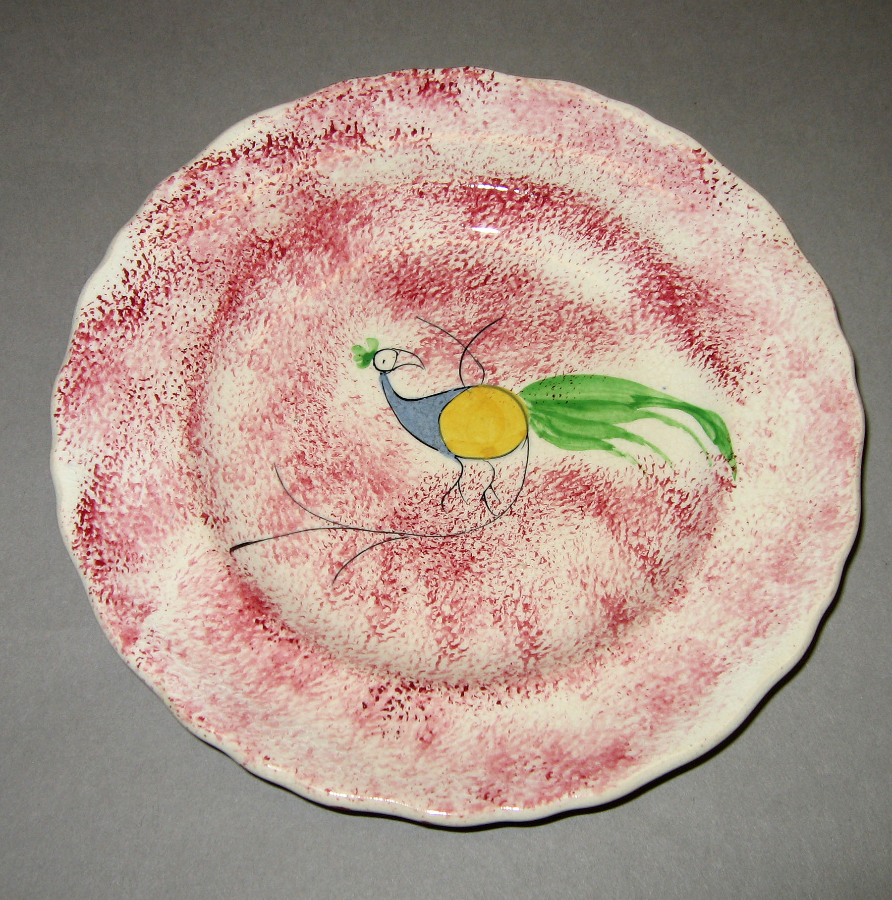 1965.0881.004 Pink spatter plate with peafowl pattern