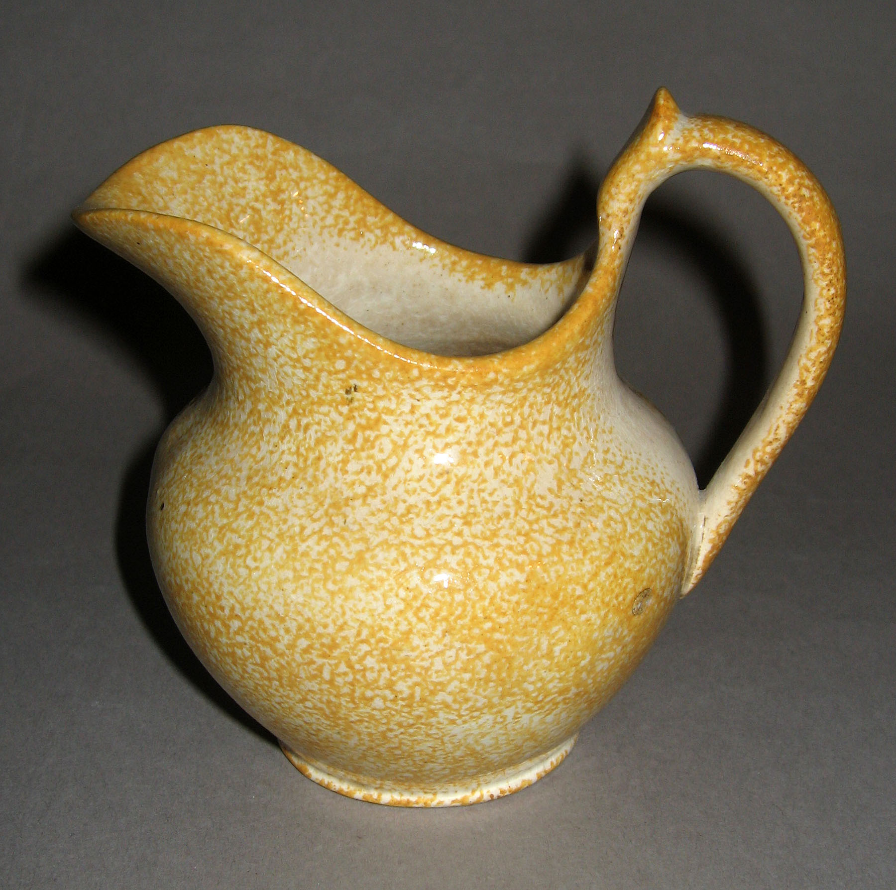 1965.0775 Yellow spatterware cream jug