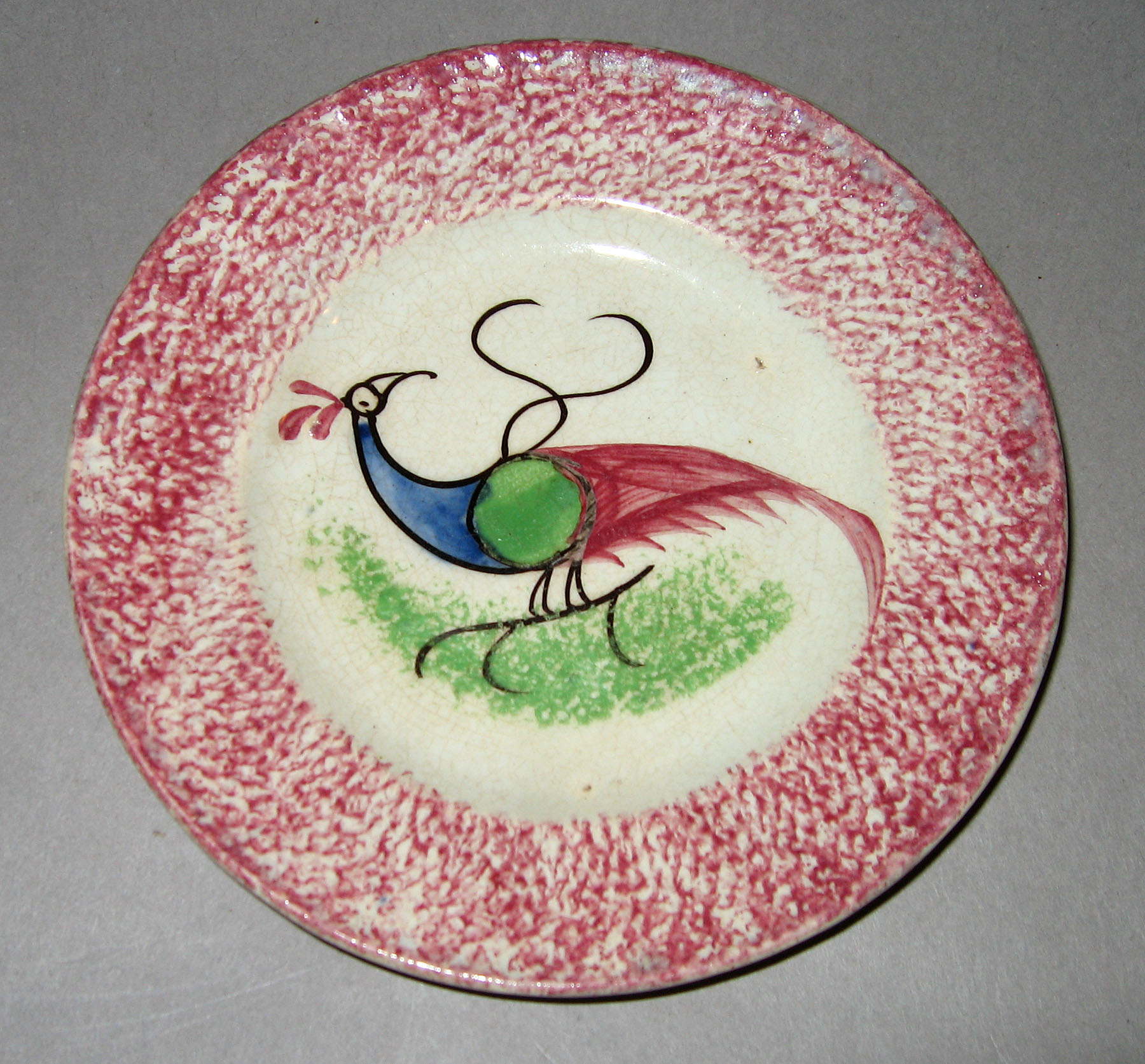 1965.0896.003 Pink spatterware peafowl plate