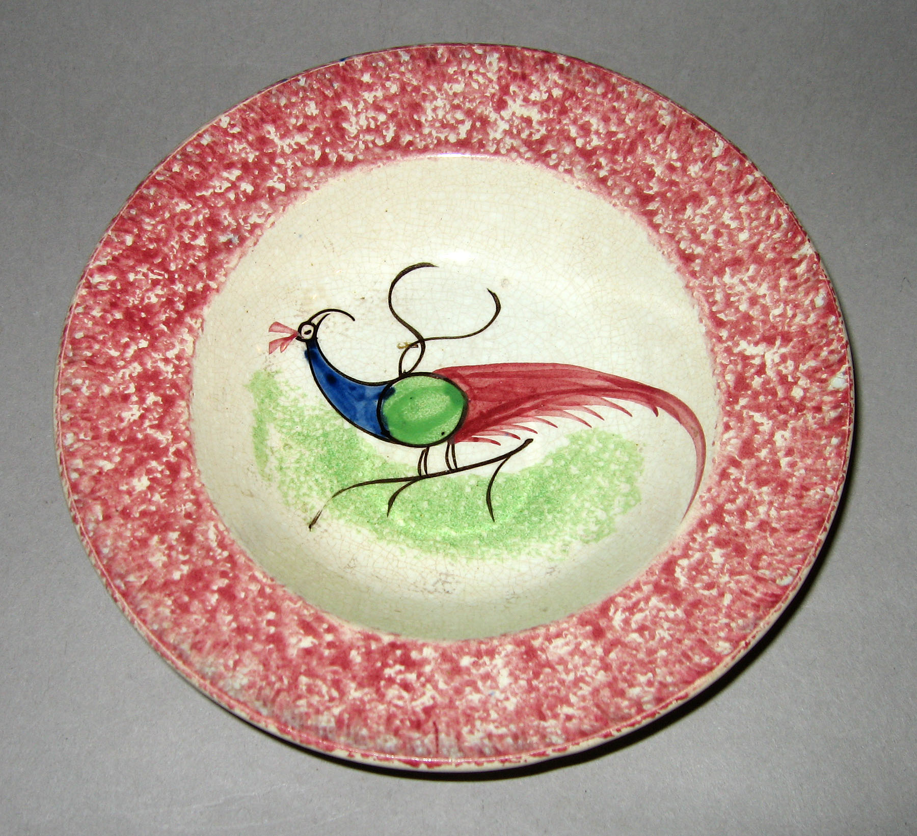 1965.0896.005 Pink spatterware peafowl saucer