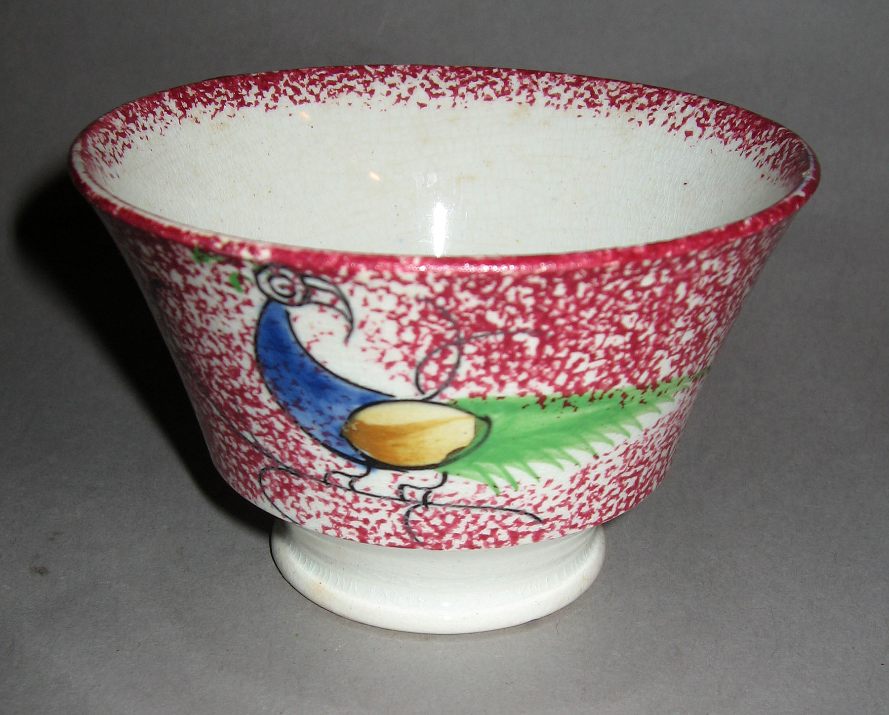 1965.0887.001 Pink spatterware peafowl teabowl