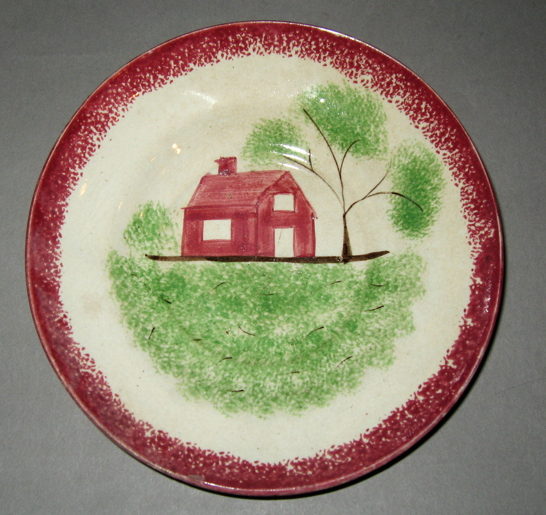 1965.0776.005 Pink spatterware schoolhouse pattern saucer