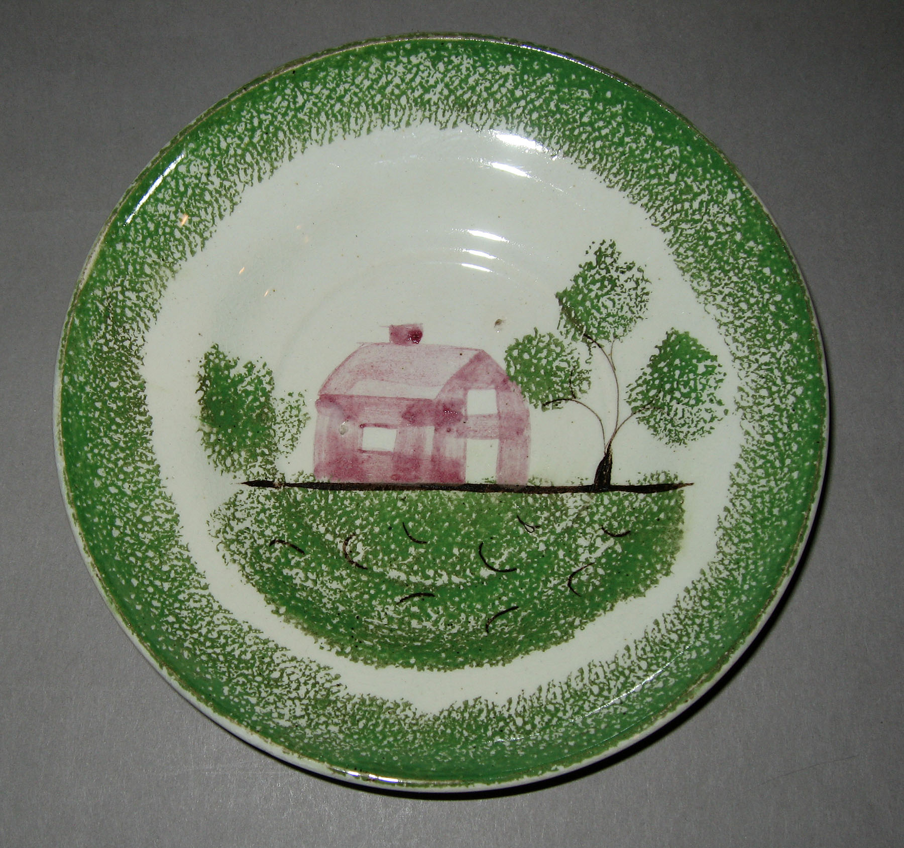 1965.0784 Green spatterware school house pattern saucer