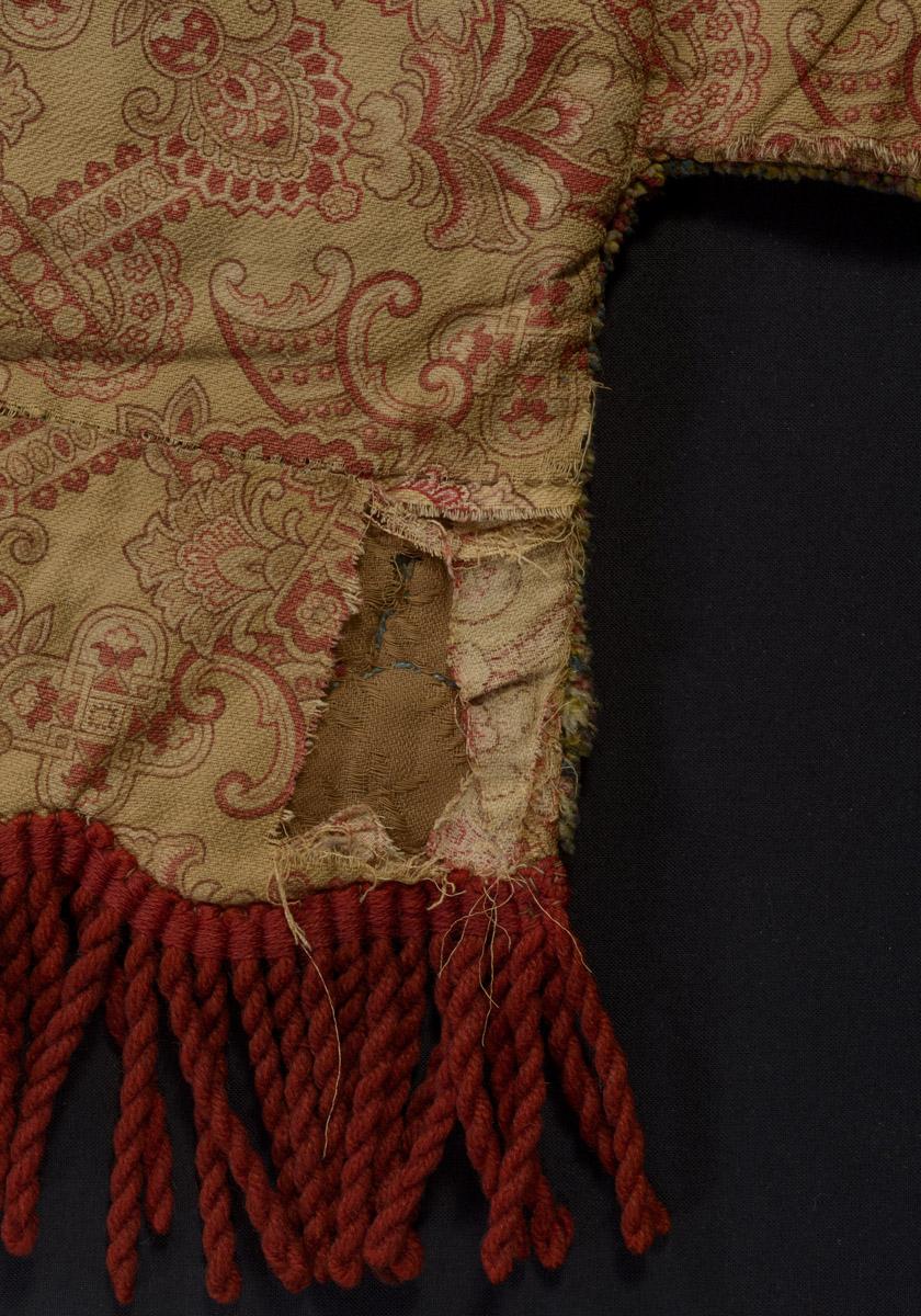 1970.1528 Chair cover, reverse, detail 1, before conservation treatment