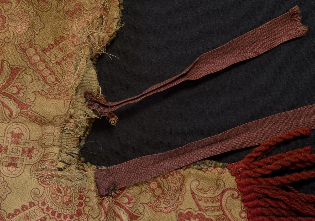1970.1528 Chair cover, reverse, detail 3, before conservation treatment