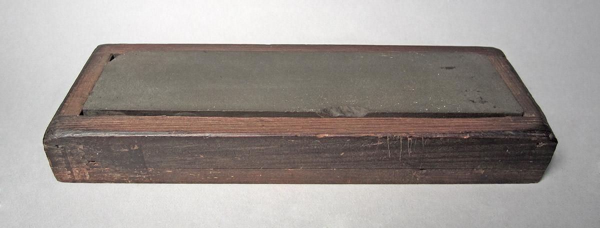 1986.0050.440 A, B, Oil stone and box, overall angle