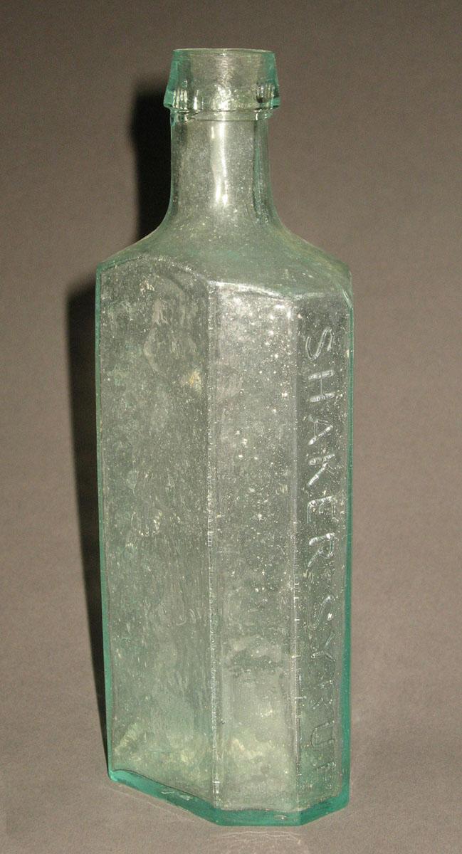 1961.0205.001 Glass syrup bottle (side 1)