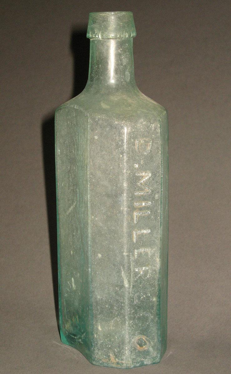 1961.0205.002 Glass syrup bottle (side 1)