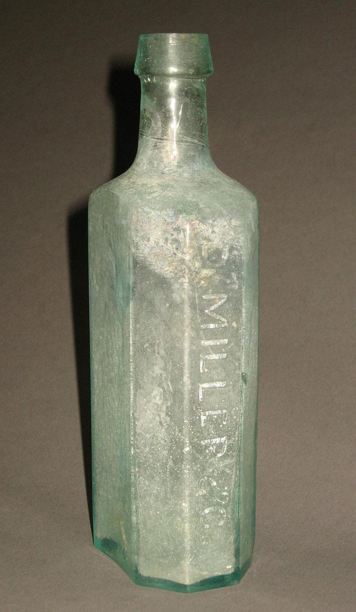 1961.0205.003 Glass syrup bottle (side 1)