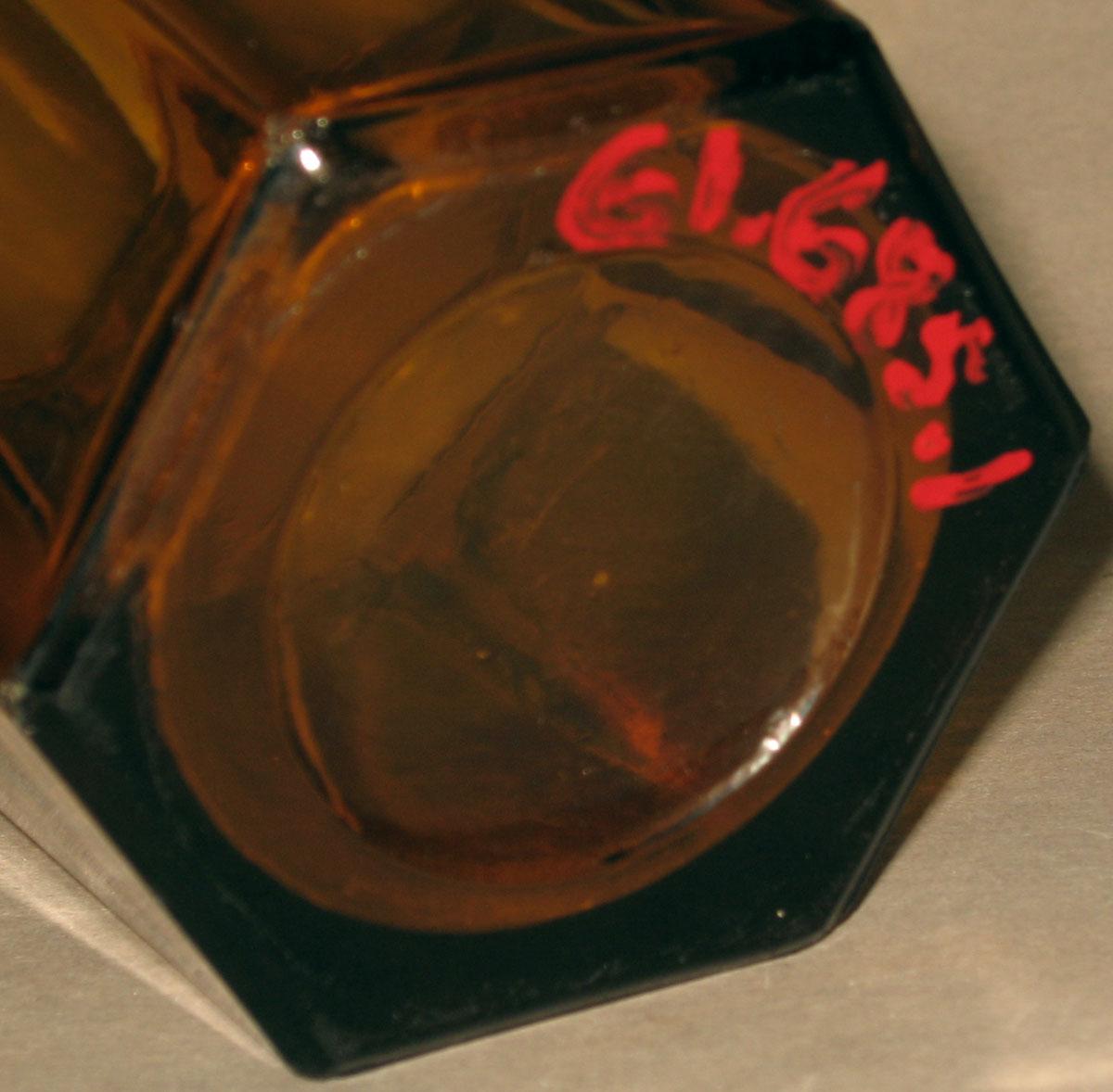 1961.0685.001 Amber pressed glass tumbler (underside)