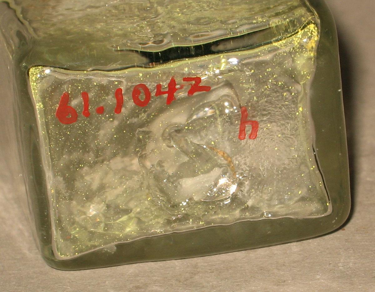 1961.1042 H Glass bottle (underside)