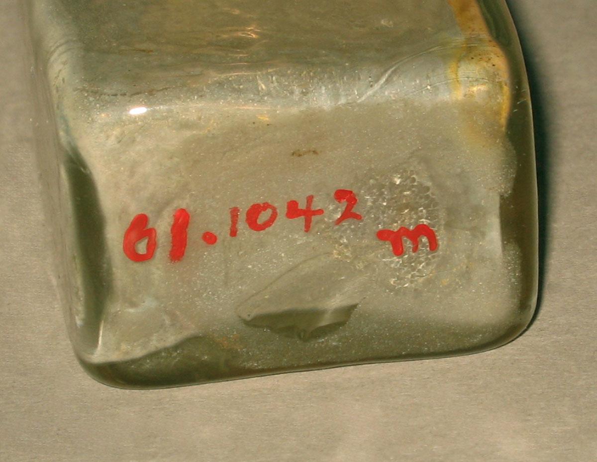 1961.1042 M Glass bottle (underside)