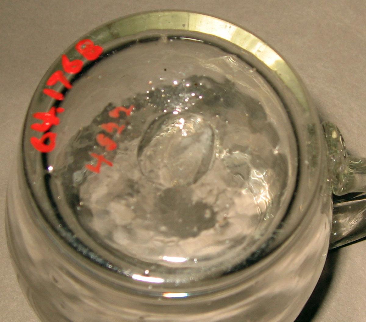 1964.1768 Colorless glass mug (underside)