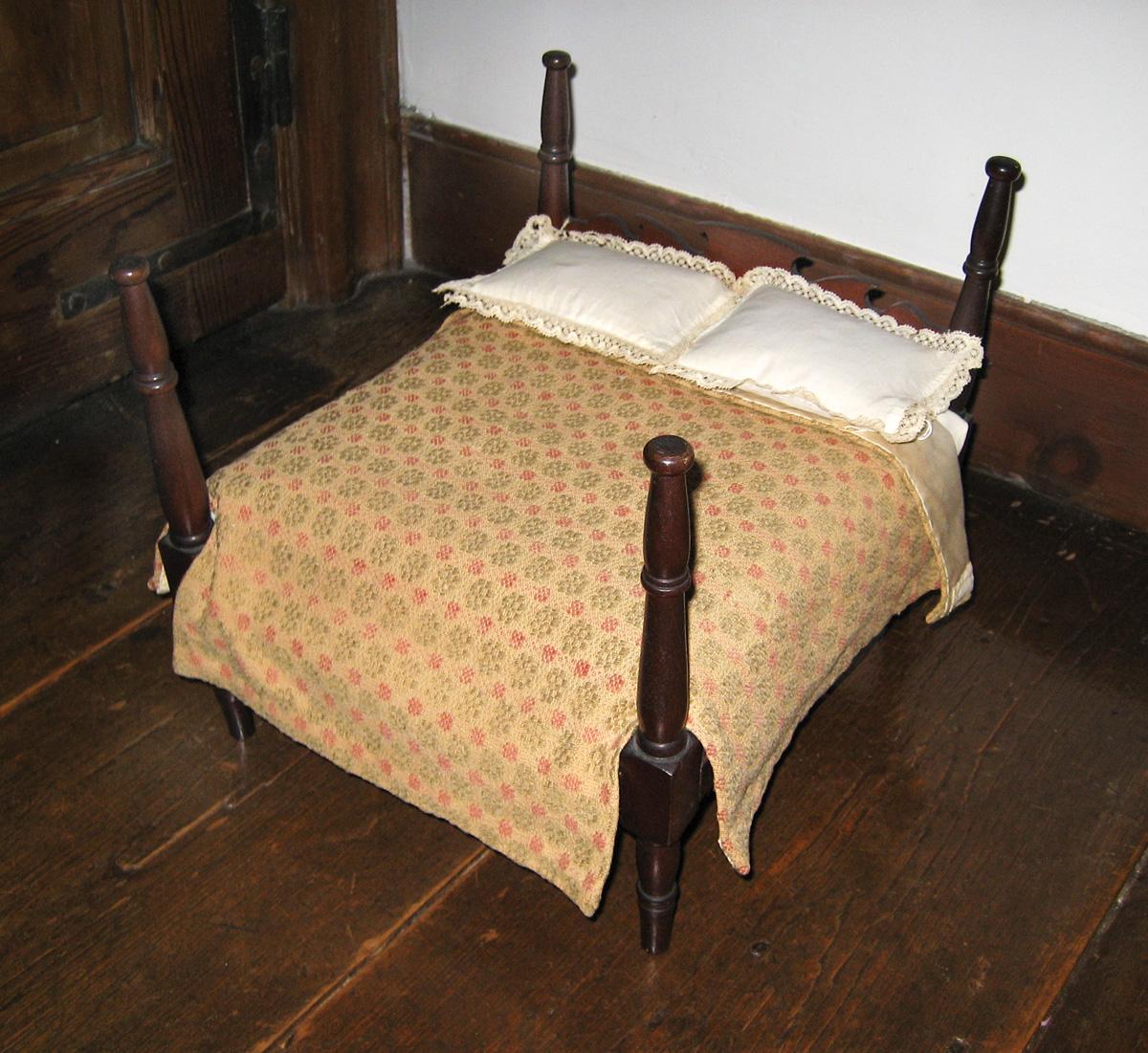 1969.0676 miniature coverlet, 1964.2196 and 1964.2197 miniature pillows on 1961.1774 Miniature bed