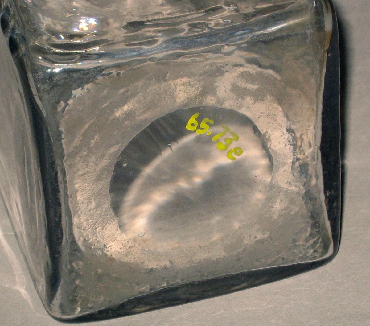 1965.0073 E Colorless glass case bottle (underside)
