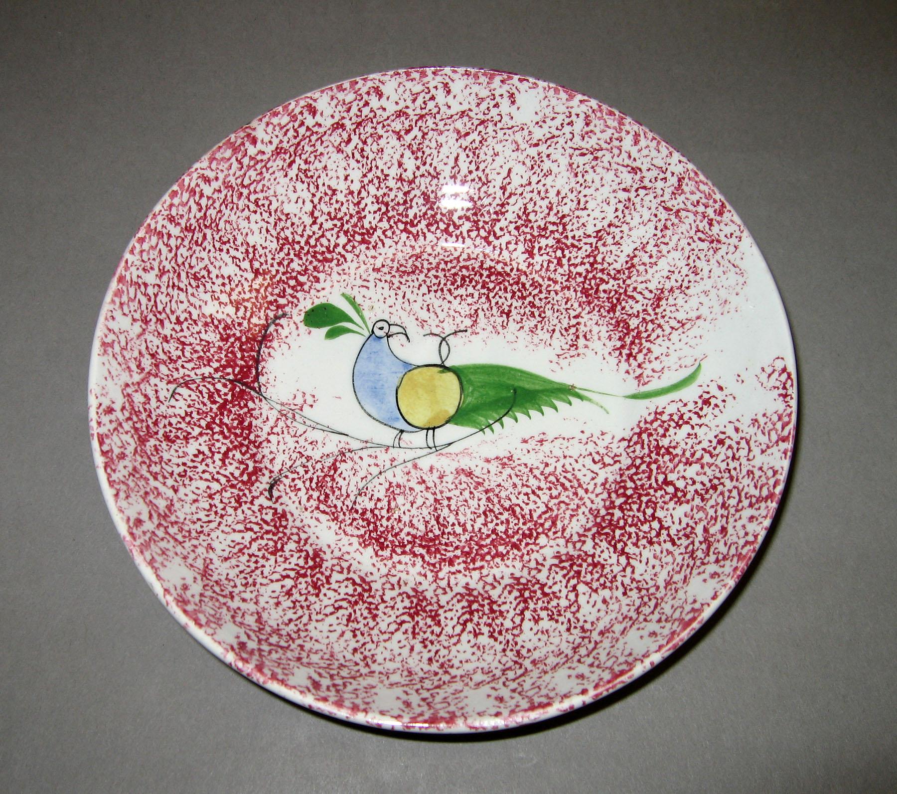 1965.0884 Pink spatter saucer with peafowl pattern