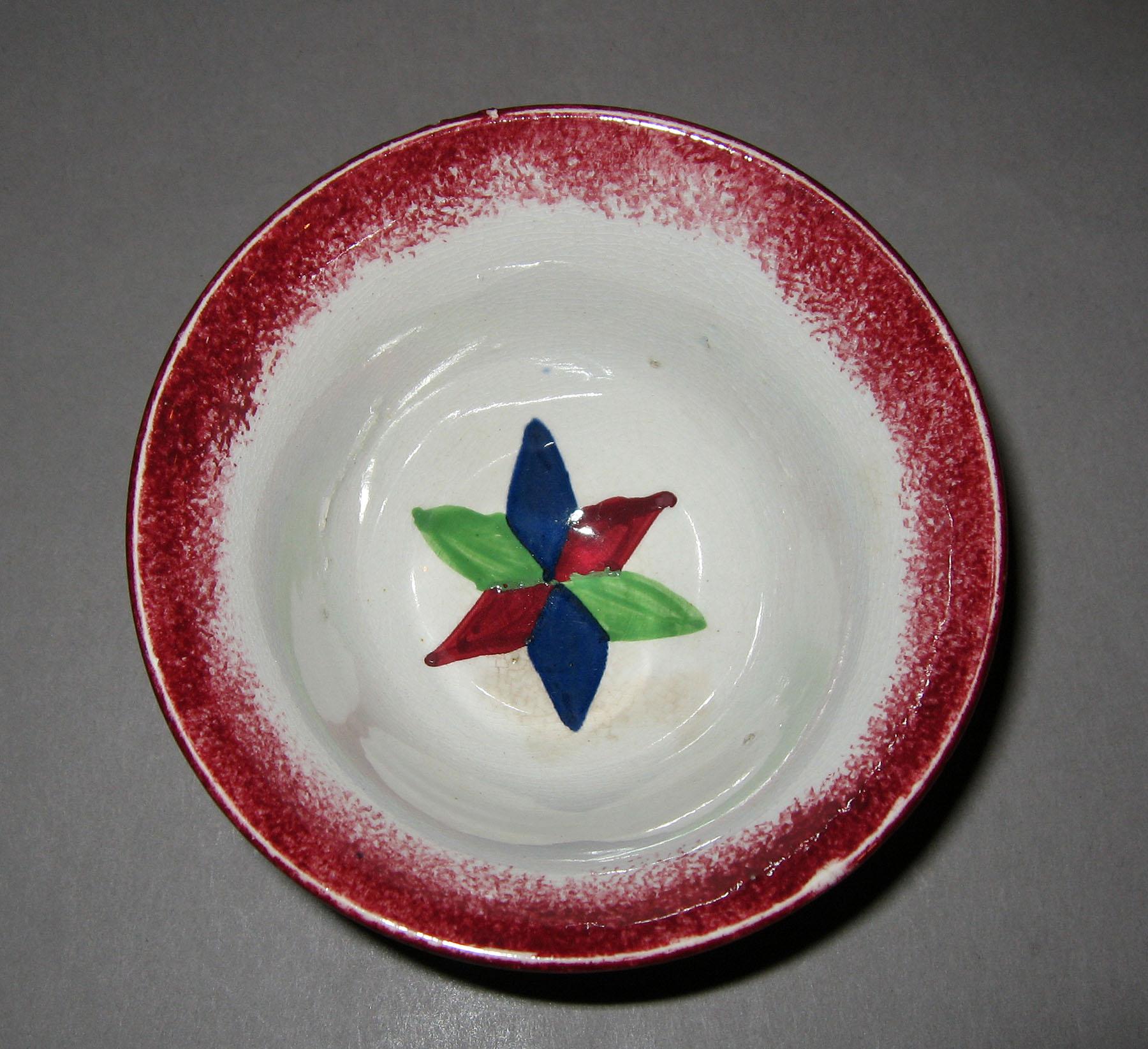 1965.0903.003 Red spatterware star pattern teabowl (interior)