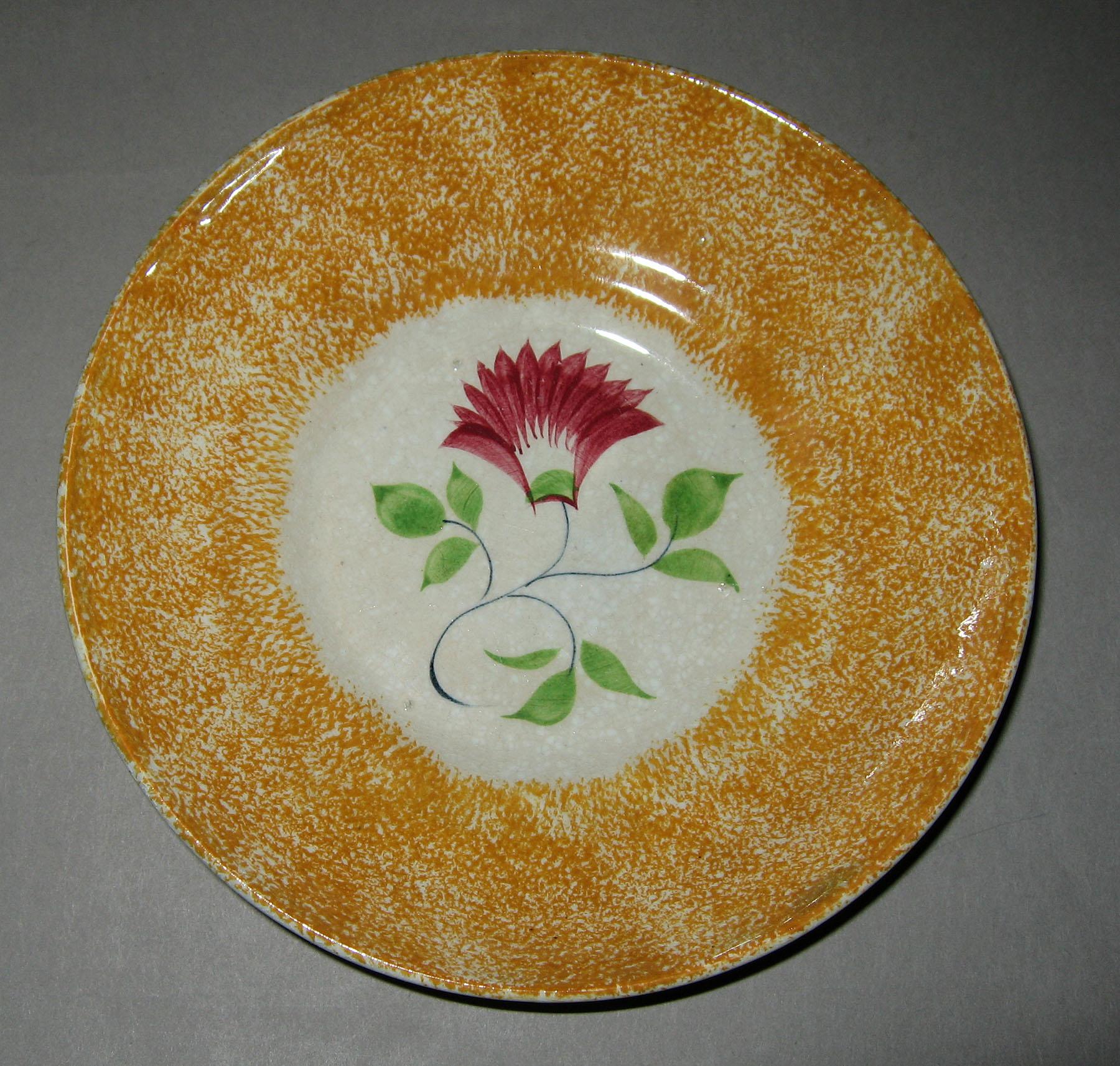 1965.0918.003 Yellow spatterware with pink thistle saucer