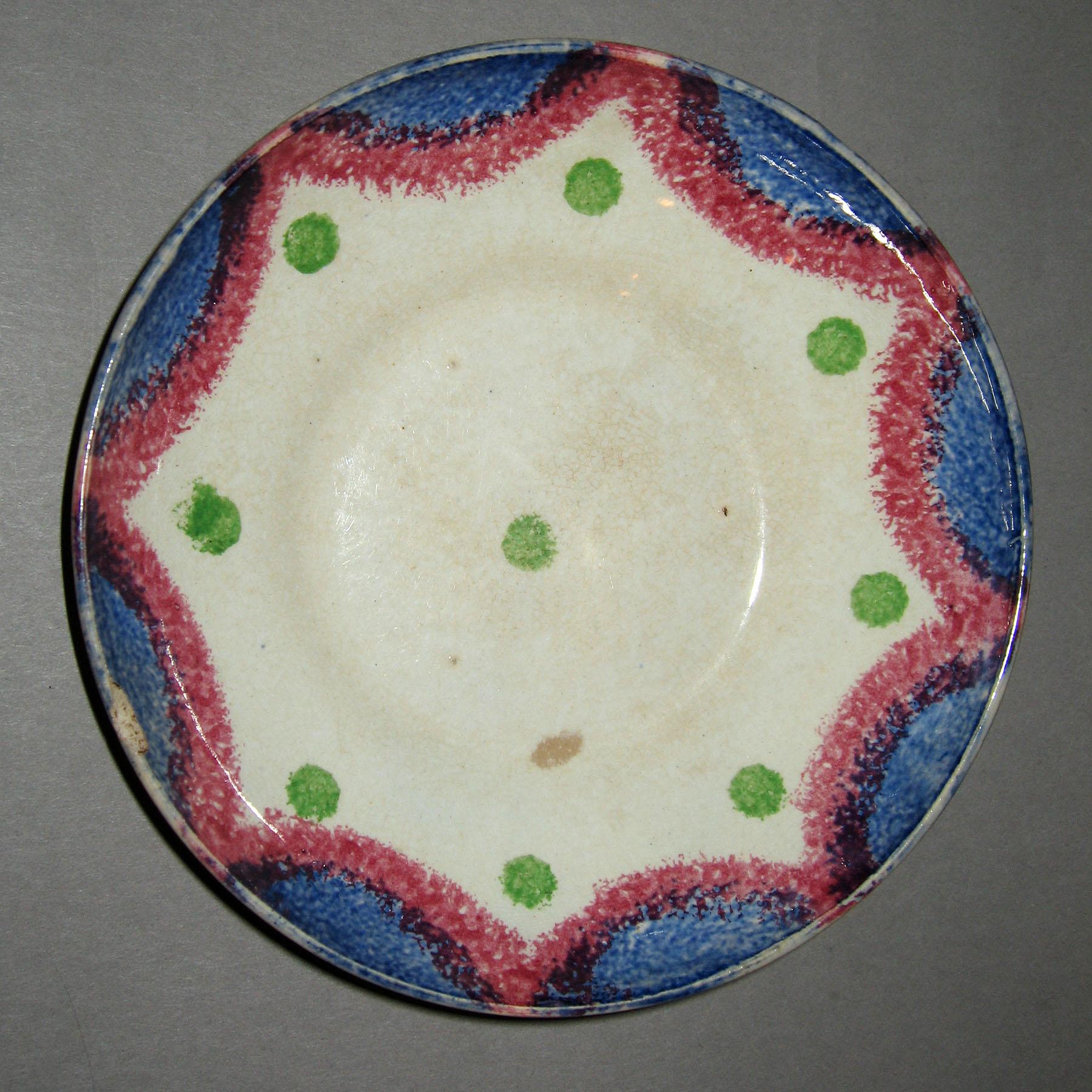 1965.0944.004 Drape and dot spatterware saucer
