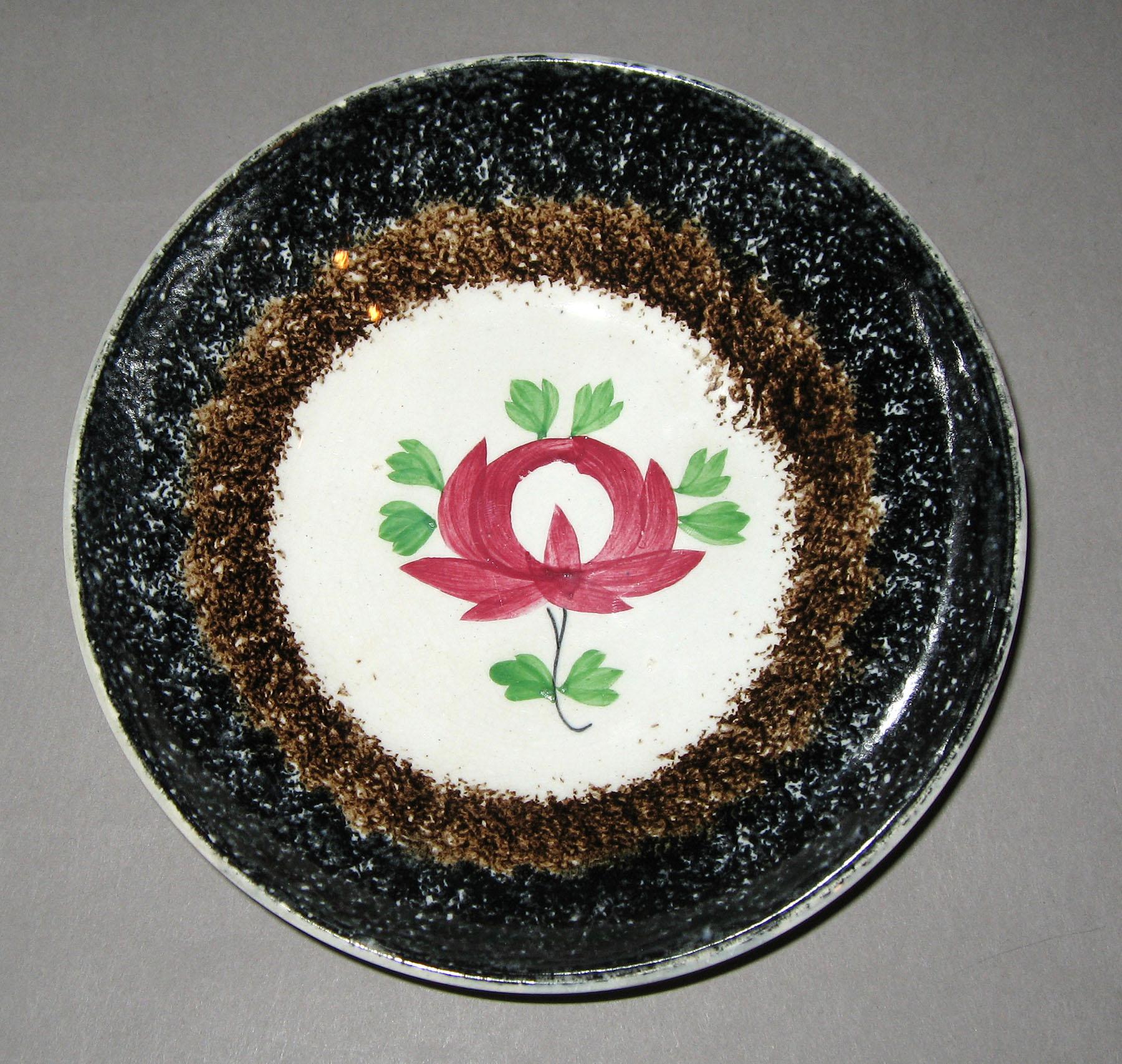 1965.0955 Black and brown spatterware rose pattern saucer