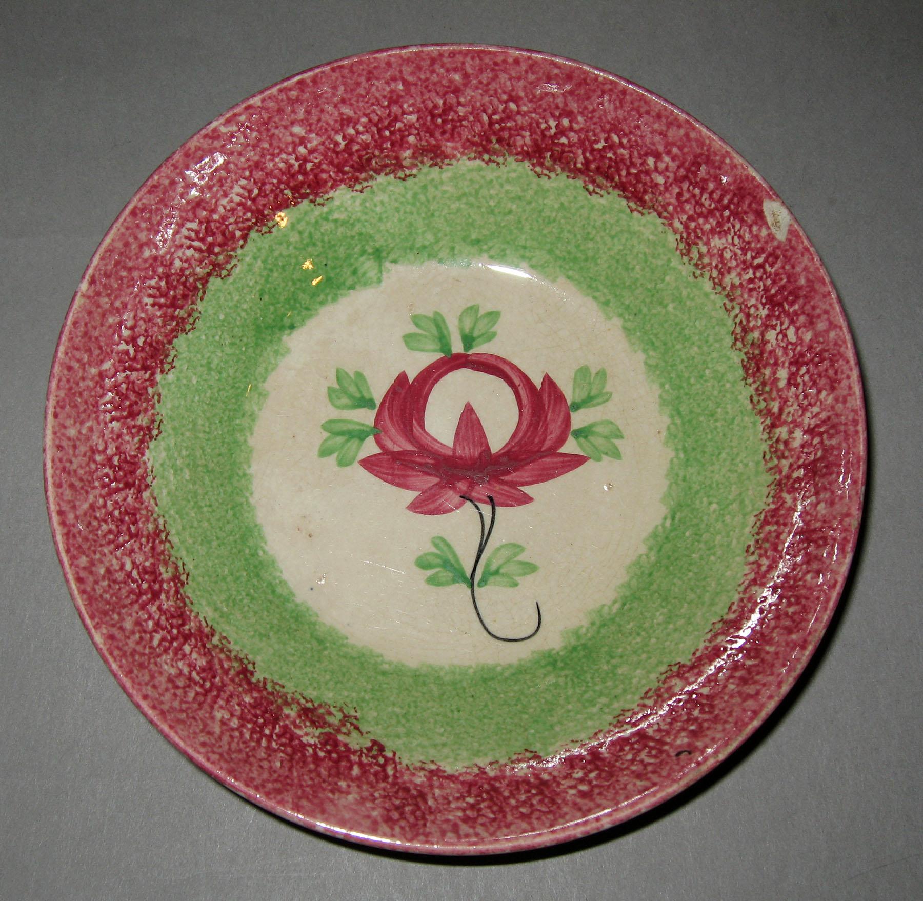 1965.0958.003 Pink and green spatterware rose pattern saucer