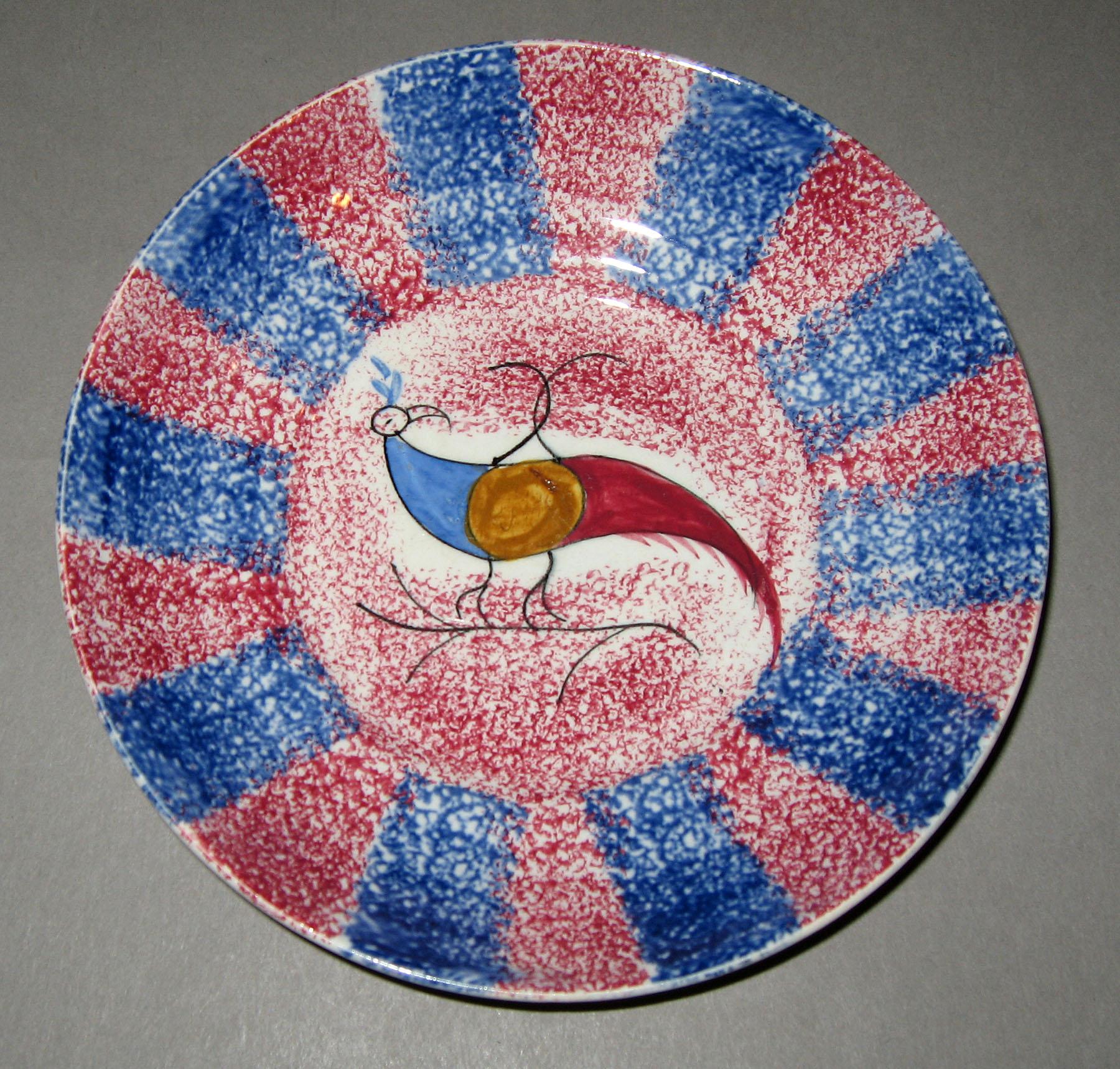 1965.1024.002 Pink and blue spatterware peafowl saucer