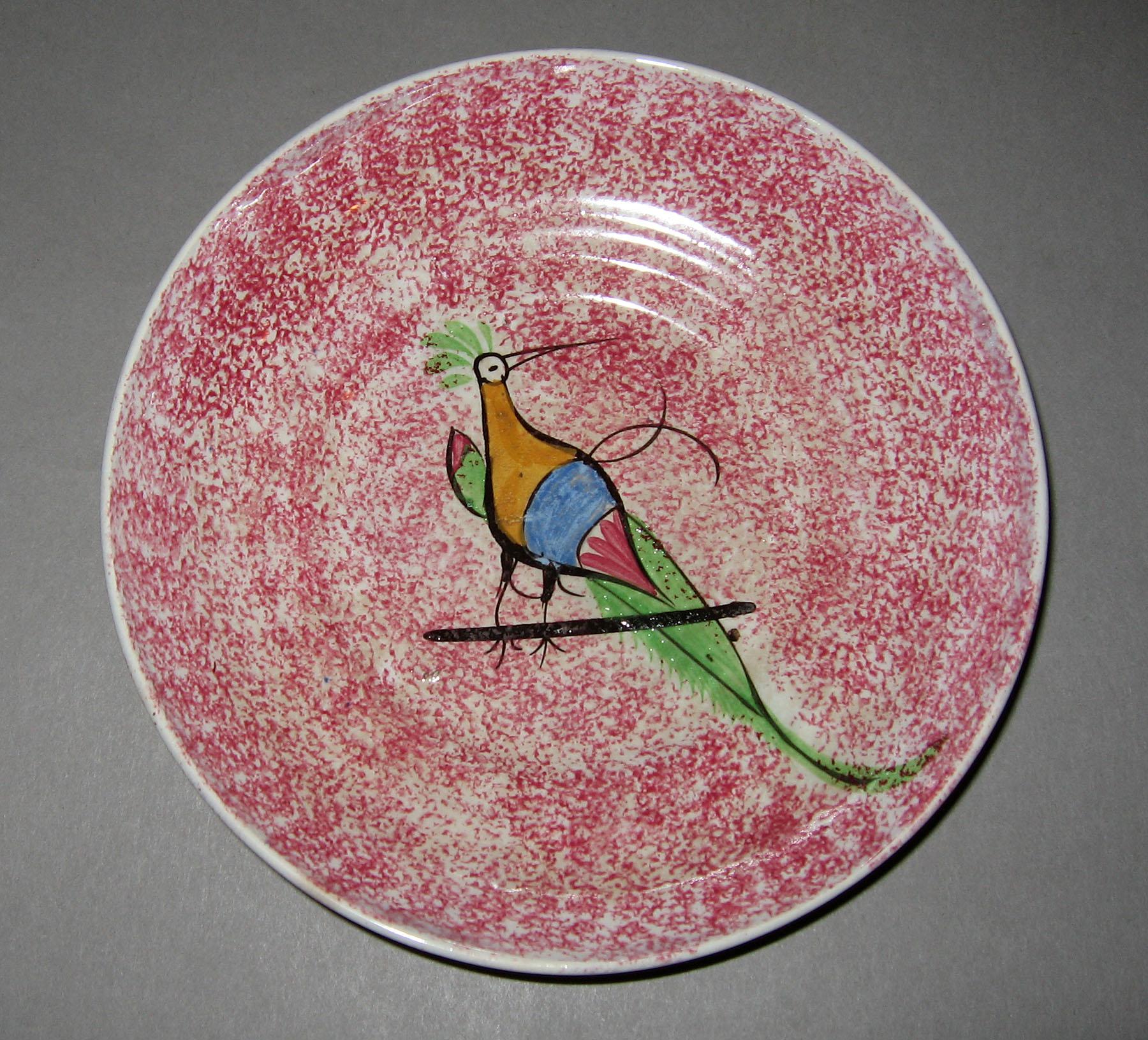 1965.1035 Red spatterware bird on a bar pattern saucer