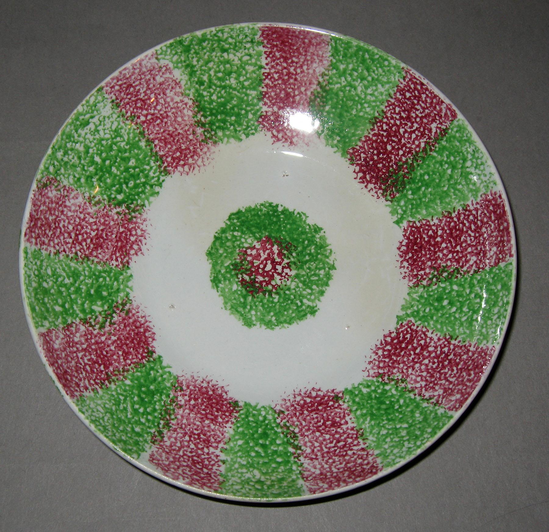 1965.1084 Pink and green rainbow stripe spatterware saucer