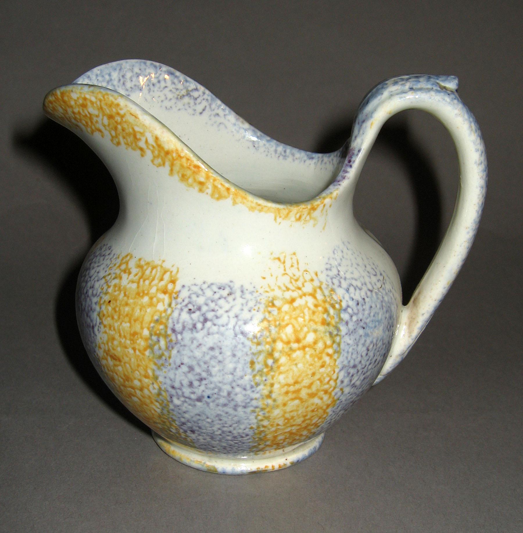 1965.1222 Yellow and blue striped spatterware cream jug