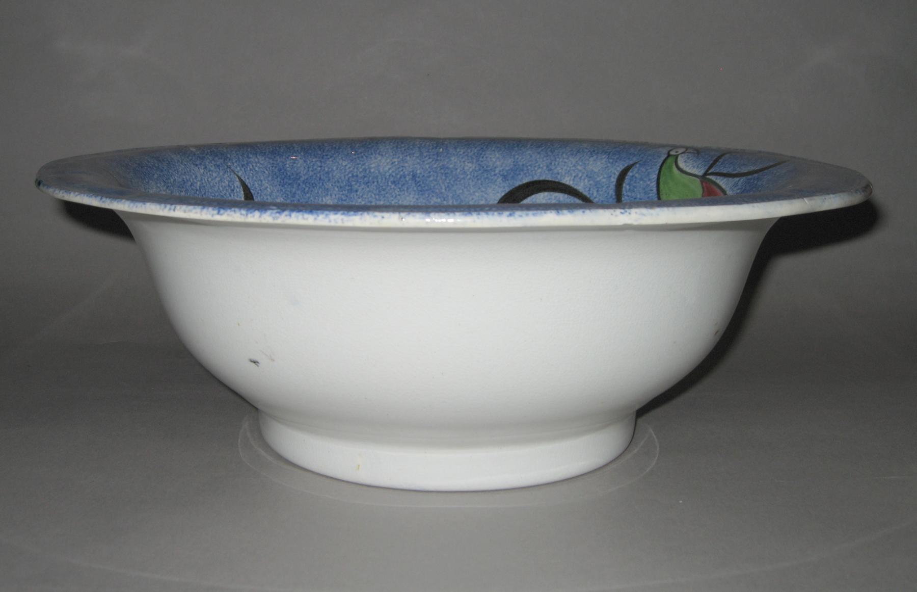 1967.0028 B Blue spatterware and peafowl bowl (side view)