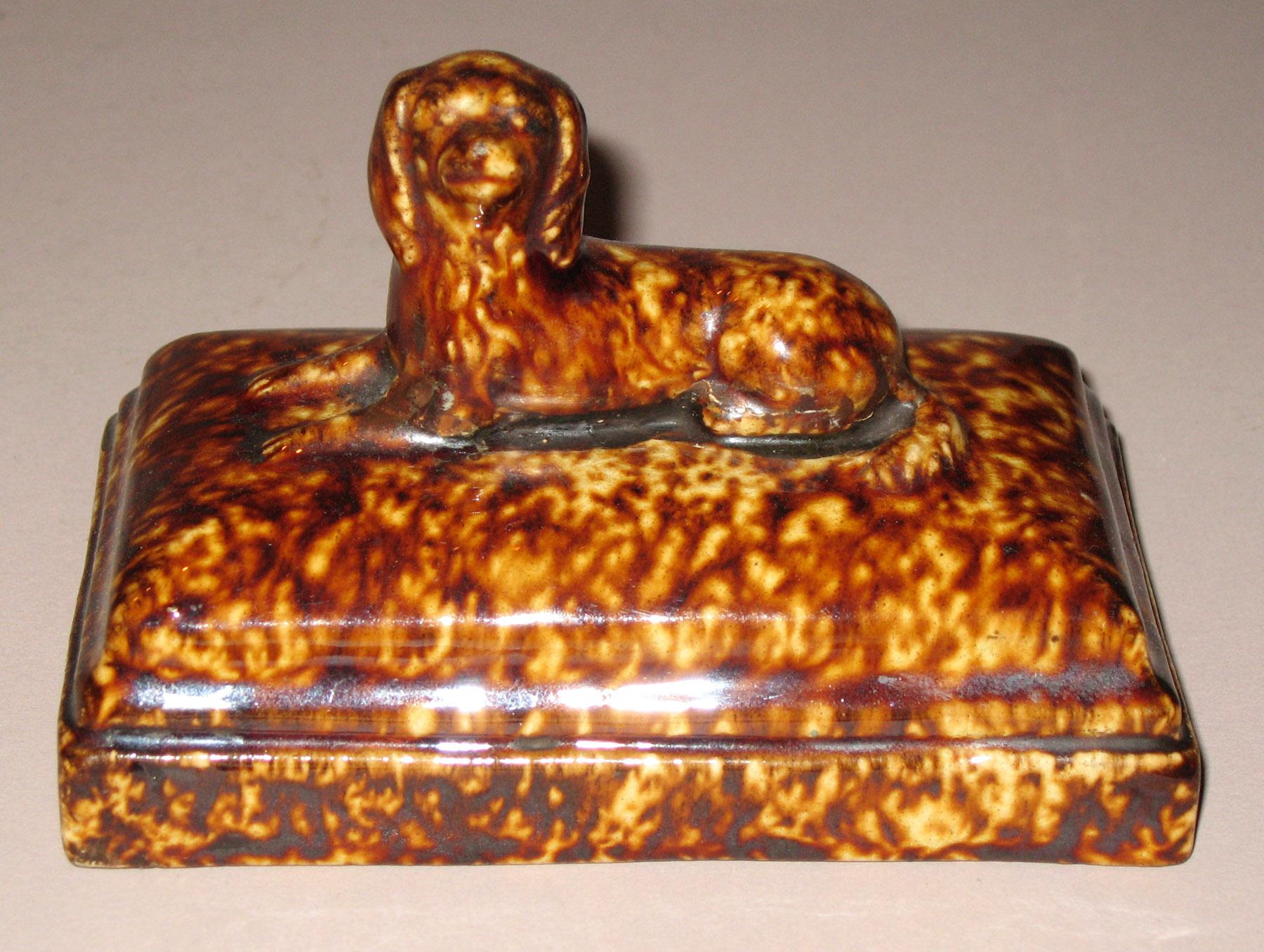 1967.1861 Earthenware dog  on cushion