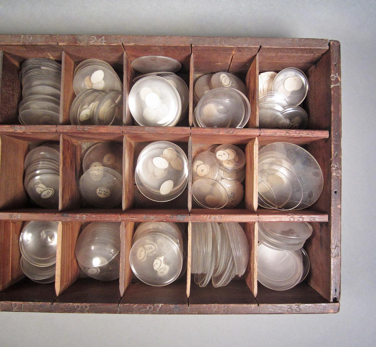 1957.0026.606, Box of watch crystals, top detail 1