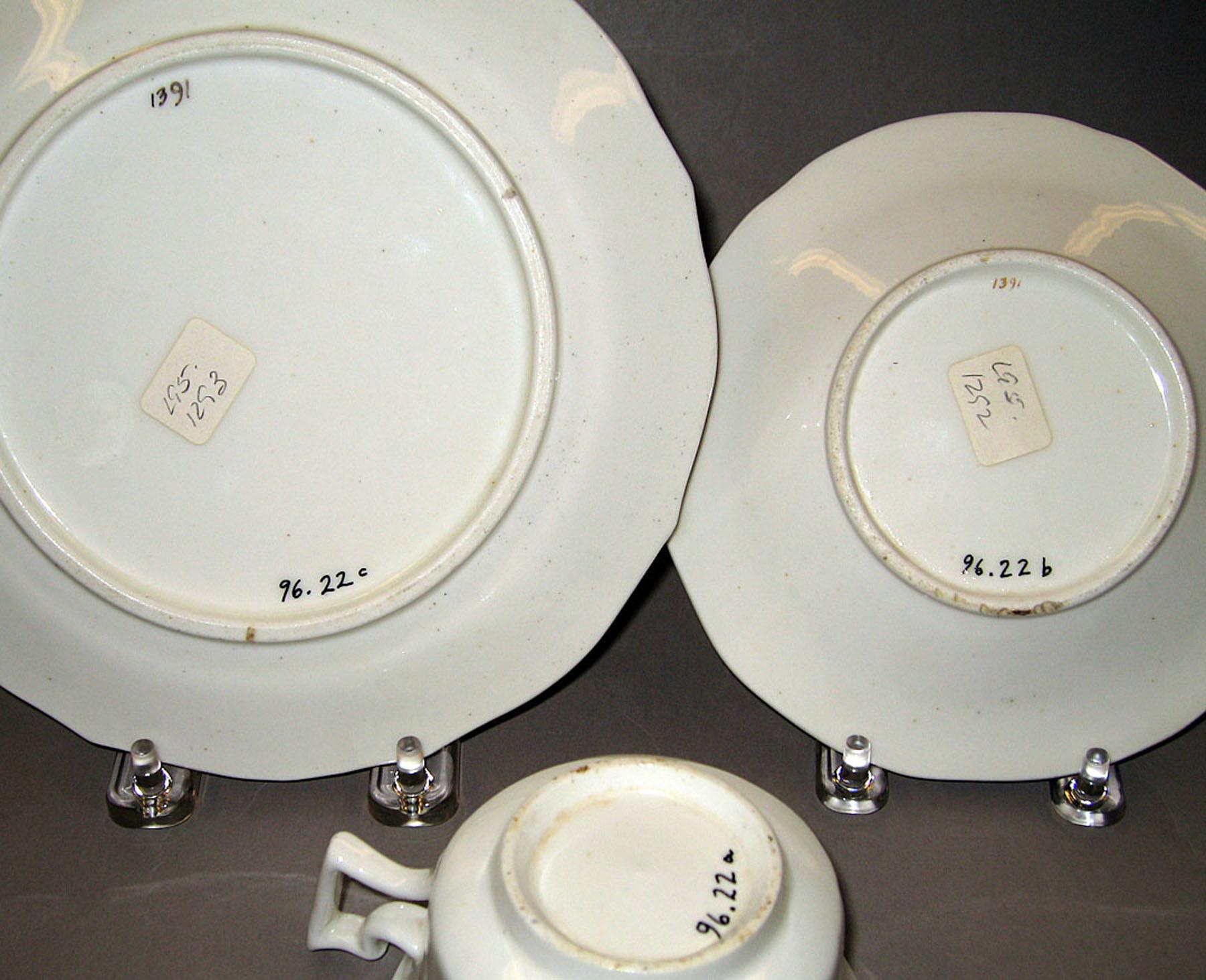 1996.0022 A-C Bone-china teacup, saucer, and plate (undersides)